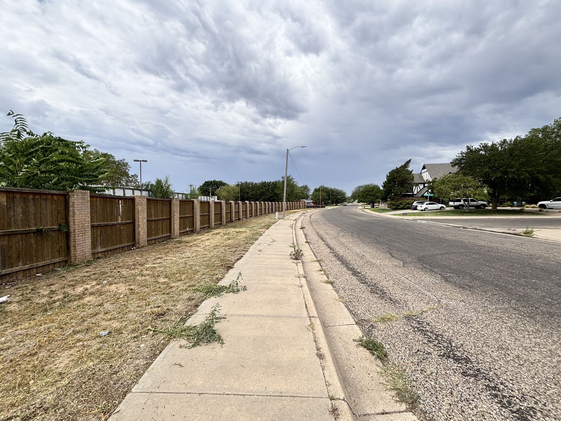 The same fence line cut back and cleaned after lawn service