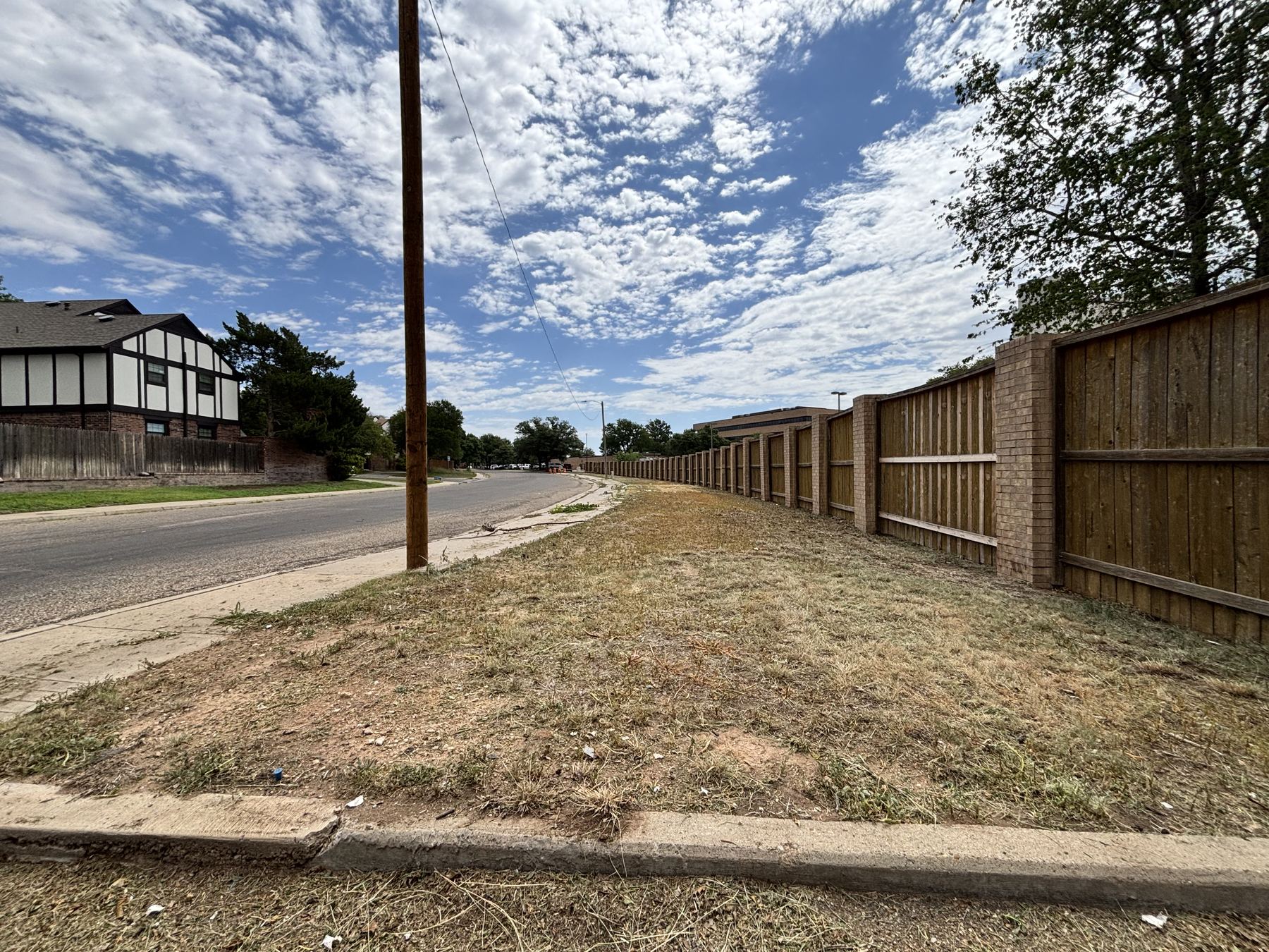 Cleaned and mowed lawn beside a long fence line